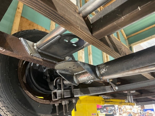 Underside of a trailer showing custom welded air suspension brackets and frame work