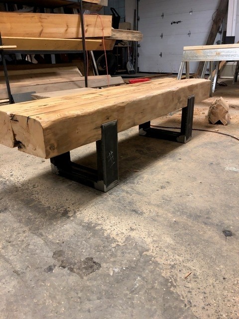 Thick live-edge wood beam bench on blackened steel U-shaped legs