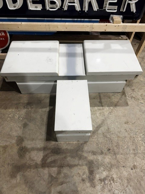 Long white fabricated steel tool box with three hinged lids on a shop floor