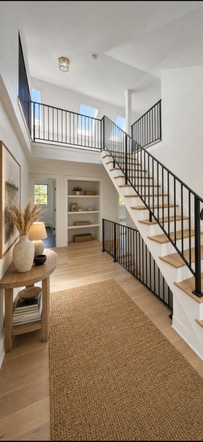 Custom black steel stair railing and landing guardrail in a bright entryway