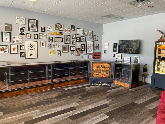 Custom steel and wood glass display cases along a tattoo studio wall