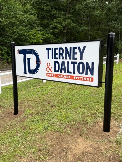 Roadside sign in a black steel frame mounted on two round posts