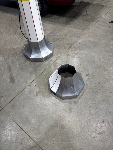 Two octagonal formed aluminum skirt bases, one installed on a sign post