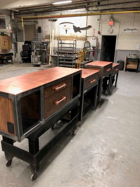 Steel work stations with copper tops, wood drawers, and casters